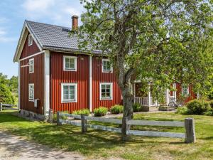 ein rotes Haus mit einem Zaun davor in der Unterkunft Holiday Home Gåragöl - B in Olofström