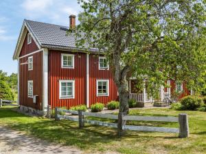 a red house with a fence in front of it at Holiday Home Gåragöl by Interhome in Olofström