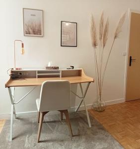 un bureau avec une chaise à côté d'une table et d'une imprimante dans l'établissement Maison de ville calme, à La Roche-sur-Yon