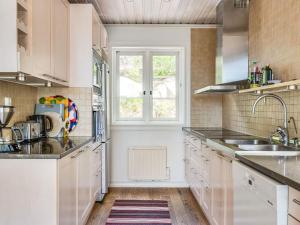 een keuken met witte kasten en een raam bij Holiday Home Bergstigen Gunnebo by Interhome in Gunnebo