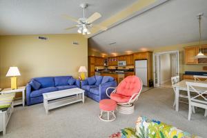 a living room with blue couches and a kitchen at Chocowinity Waterfront Getaway with Boat Dock! in Chocowinity
