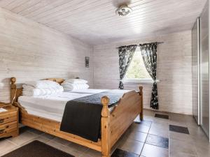 een slaapkamer met een groot houten bed in een kamer bij Holiday Home Erikstorp Fyran by Interhome in Olofström