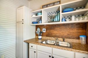 a kitchen with a sink and white cabinets at New Braunfels Vacation Rental on Lake Dunlap! in New Braunfels +20 photos