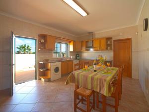 a kitchen with a table with chairs and a table and a tableablish at Holiday Home Alto da Rafoia by Interhome in Lagoa +25 photos
