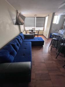 a living room with a blue couch and a table at Elegante departamento in Iquique