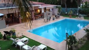 una gran piscina con sillas y una casa en B&B EL Litoral en Playa Coronado