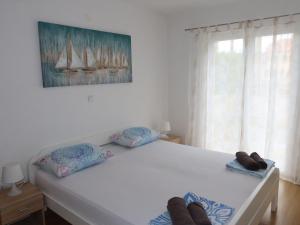 1 dormitorio con 1 cama con 2 almohadas y ventana en Apartment Kampanel-2 by Interhome, en Privlaka