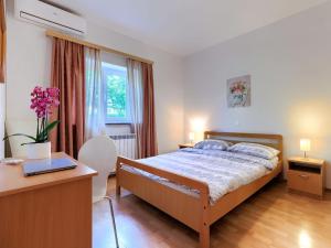 a bedroom with a bed and a desk with a laptop at Apartment Mir by Interhome in Vošteni