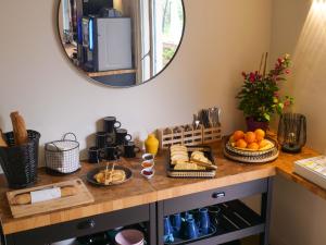 a table with bread and fruit on it with a mirror at Lou Riou Village Vacances in Saint-Tropez