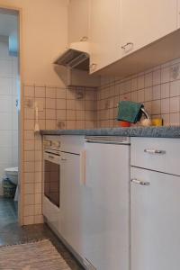 - une cuisine avec des appareils électroménagers blancs et un comptoir dans l'établissement Apartment Daheim by Interhome, à Zweisimmen