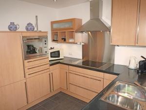 ラディスにあるApartment Ladis-11 by Interhomeのキッチン(木製キャビネット、シンク、電子レンジ付)