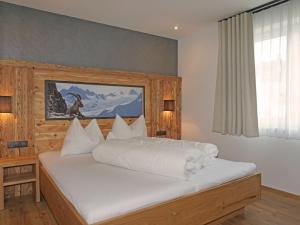 a bedroom with a large white bed in it at Apartment Ladis-11 by Interhome in Ladis