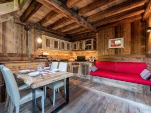 una sala da pranzo con divano rosso e tavolo di Chalet Chalet les Combes by Interhome a Introd
