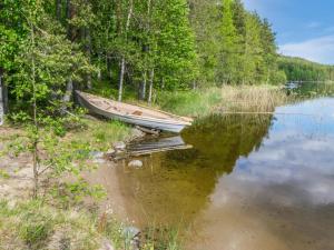 um barco sentado na margem de um lago em Holiday Home Lohi- cjoe237 a by Interhome em Säynetlahti