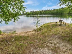 uma mesa de piquenique e banco na margem de um lago em Holiday Home Lohi- cjoe237 a by Interhome em Säynetlahti