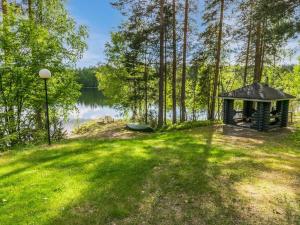 een prieel in het gras naast een meer bij Holiday Home Lohi- cjoe237 a by Interhome in Säynetlahti