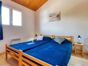 モビュイソンにあるHoliday Home Les hameaux de l'Océan by Interhomeのベッドルーム1室(青い掛け布団付きのベッド1台付)