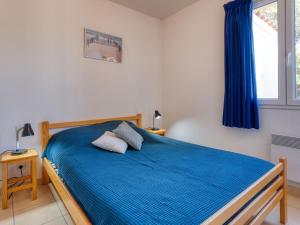 モビュイソンにあるHoliday Home Les hameaux de l'Océan by Interhomeのベッドルーム1室(青いシーツと窓付)