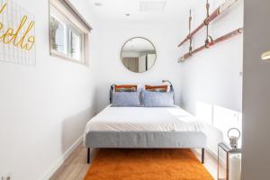 een slaapkamer met een bed en een spiegel bij Brand New! 3-bedroom Apartment with Private Sunny Patio in Cacilhas! in Almada