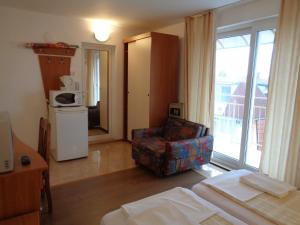 a room with a bed and a chair and a window at Стаи за гости" Герови" in Nesebar