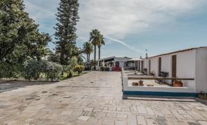 an empty courtyard with trees and a building at Humus Farm in Águas de Moura