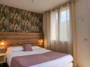 a bedroom with a large bed and a window at Lou Riou Village Vacances in Saint-Tropez