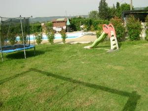 un parque con parque infantil con tobogán y piscina en Casa Marblu via Cairoli, 47 Corciano, en Corciano