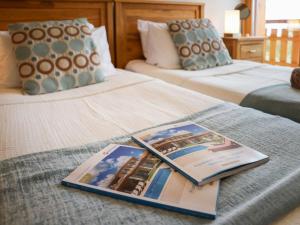 ein Hotelzimmer mit einem Buch auf einem Bett in der Unterkunft Apartment Domaine des Reines D3 by Interhome in Nendaz