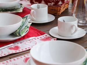 einem Holztisch mit weißen Tassen und Tellern darauf in der Unterkunft Apartment Domaine des Reines D3 by Interhome in Nendaz