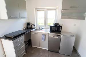 a small kitchen with a sink and a microwave at Apartamenty Tęczowa 14 Sarbinowo in Sarbinowo