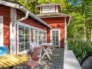 a cabin with a table and chairs on a deck at Chalet Villa Lundsfjärden - VML120 by Interhome in Grythyttan