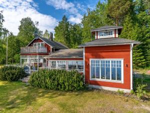 una casa con una casa roja con techo en Chalet Villa Lundsfjärden - VML120 by Interhome en Grythyttan