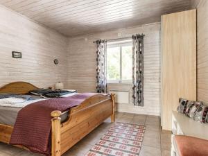a bedroom with a wooden bed and a window at Holiday Home Erikstorp Femman - B in Olofström