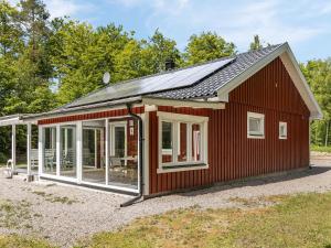 a red house with a solar roof at Holiday Home Erikstorp Femman - B in Olofström