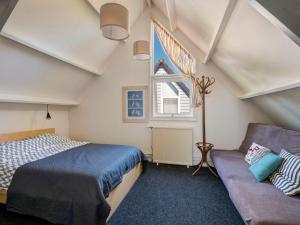 a bedroom with a bed and a couch at Holiday Home De Schans by Interhome in Anjum