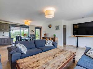 ein Wohnzimmer mit einem blauen Sofa und einem Couchtisch aus Holz in der Unterkunft Holiday Home L'Oliveraie by Interhome in Saint-Didier