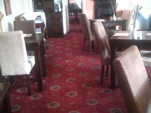 uma sala de jantar com cadeiras, uma mesa e tapete vermelho em Brackenrigg Inn em Watermillock