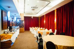 a row of tables and chairs in a room with red curtains at Hotel DarulMakmur Jerantut in Jerantut