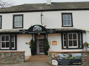 a white building with a sign in front of it at Brackenrigg Inn in Watermillock