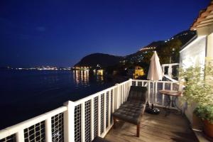 einen Balkon mit einem Tisch, einem Stuhl und Wasser in der Unterkunft FRONT BEACH PENTHOUSE in Èze