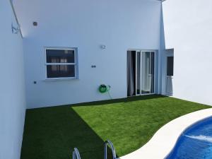 una casa con piscina y césped verde en MARINA 21 en Montellano