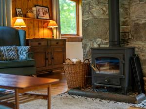a fireplace in a living room with a stove at Holiday Home Kerrow Cottage by Interhome in Inverness