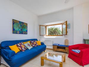 un soggiorno con divano blu e sedia rossa di Holiday Home Il Giardino sul Mare by Interhome a Castiglioncello