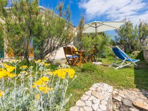 un giardino con tavolo, sedie e ombrellone di Holiday Home Il Giardino sul Mare by Interhome a Castiglioncello