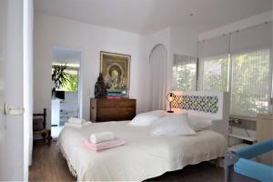 a bedroom with a large white bed with pink towels on it at FRONT BEACH PENTHOUSE in Èze