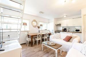 a living room with a white couch and a table at Küstenwind in Zandvoort