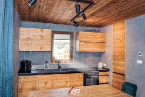 a kitchen with wooden cabinets and a sink and a window at Biały Miś in Jaworki