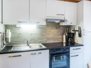 eine Küche mit weißen Schränken und einer Spüle in der Unterkunft Holiday Home Vuokatin alma by Interhome in Vuokatti