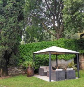 un cenador con 2 sofás y una sombrilla en La Residenza del Centro, en Padenghe sul Garda