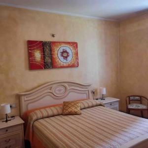 1 dormitorio con 1 cama y una pintura en la pared en La Residenza del Centro, en Padenghe sul Garda